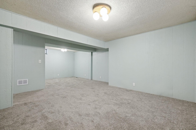 basement featuring a textured ceiling and carpet flooring