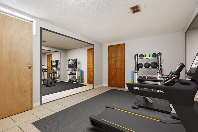 workout room with light tile patterned flooring and a textured ceiling