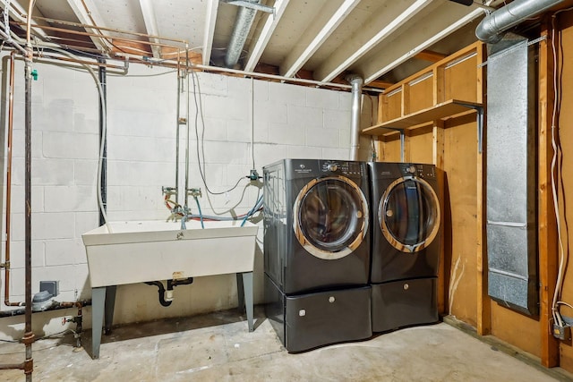 laundry area with separate washer and dryer and sink