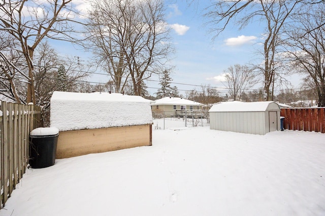 yard layered in snow with a storage shed