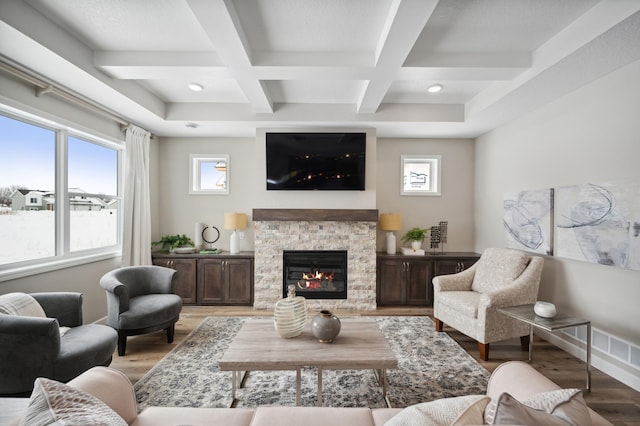 living room with a fireplace, beam ceiling, light wood-type flooring, and coffered ceiling