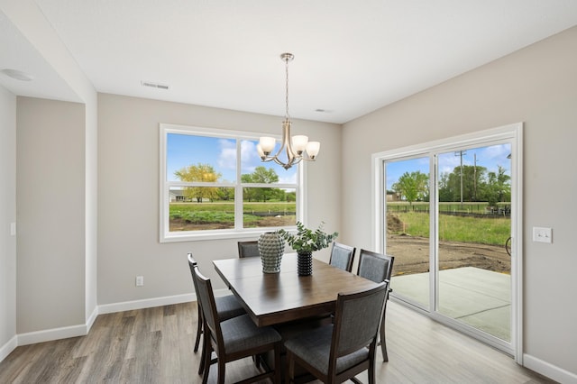 4532 86th St NE, Monticello, MN 55362 - dining area featuring a chandelier, light wood-type flooring, and baseboards
