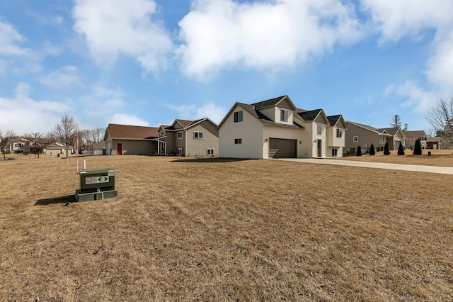 exterior space with a garage, a residential view, and a front lawn