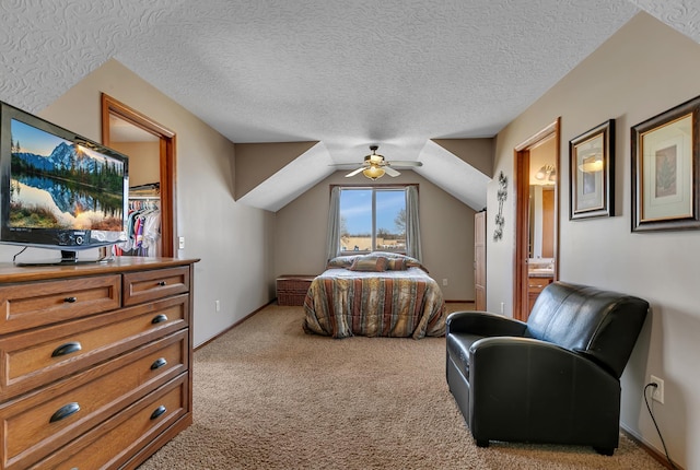 bedroom with connected bathroom, ceiling fan, vaulted ceiling, light carpet, and a textured ceiling