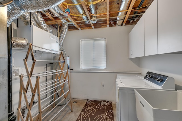 clothes washing area featuring a sink, cabinet space, water heater, and washing machine and clothes dryer