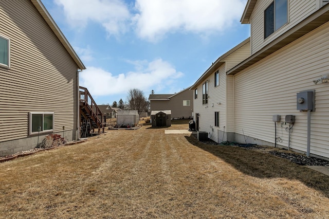 view of yard with stairs and central AC