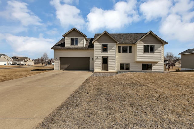 view of front of property with concrete driveway, a garage, and a front yard