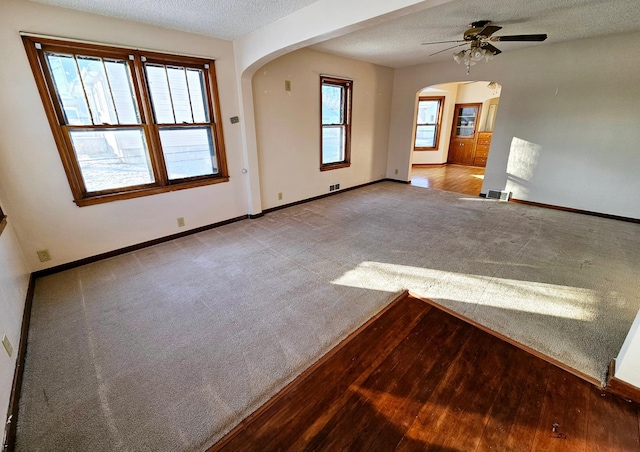 spare room featuring ceiling fan, light hardwood / wood-style flooring, and a textured ceiling