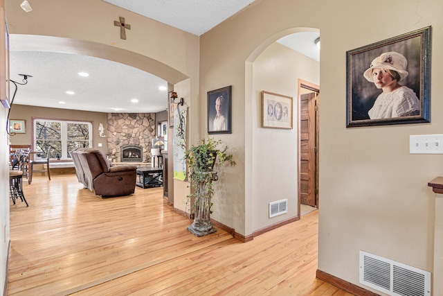 corridor featuring a textured ceiling and light hardwood / wood-style flooring