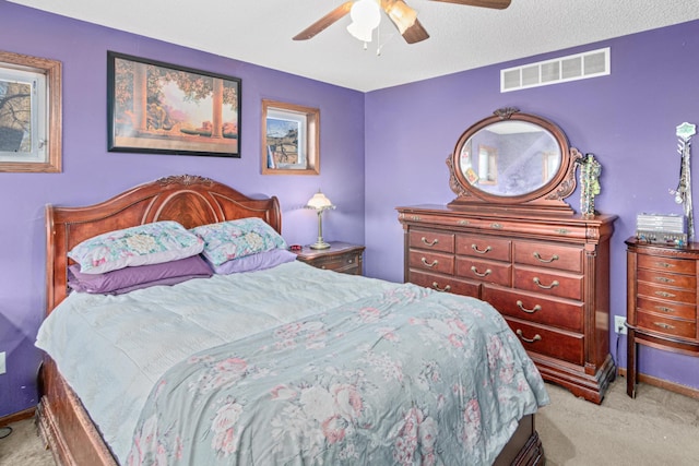 carpeted bedroom with ceiling fan and a textured ceiling