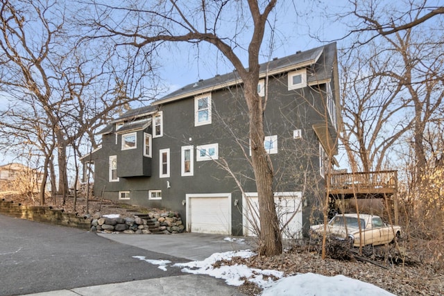 view of snowy exterior with a deck and a garage