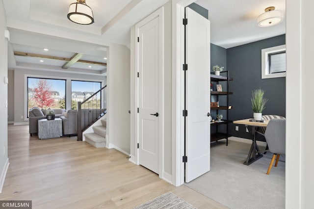 hallway with light hardwood / wood-style floors and beam ceiling