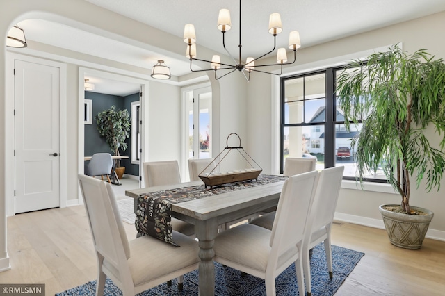 dining area featuring a notable chandelier and light hardwood / wood-style floors