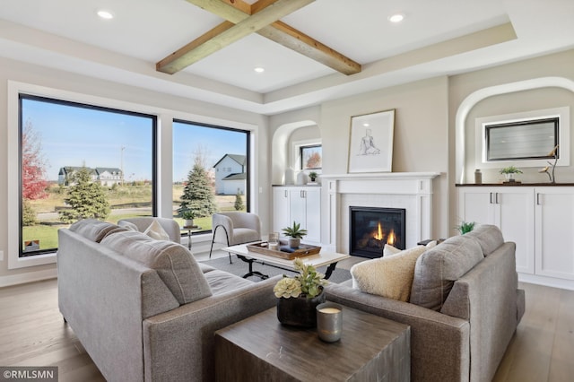 living room featuring beam ceiling and light hardwood / wood-style flooring