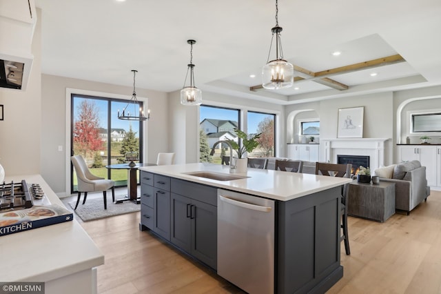 kitchen with a center island with sink, dishwasher, light wood-type flooring, and sink