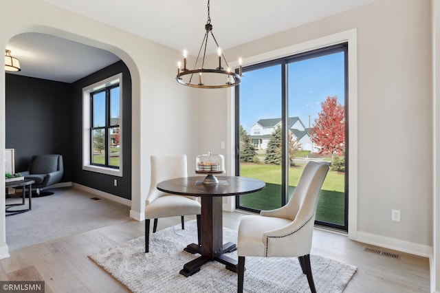 dining space with a notable chandelier and light hardwood / wood-style flooring