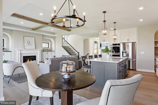 dining space with a chandelier, light hardwood / wood-style floors, and sink