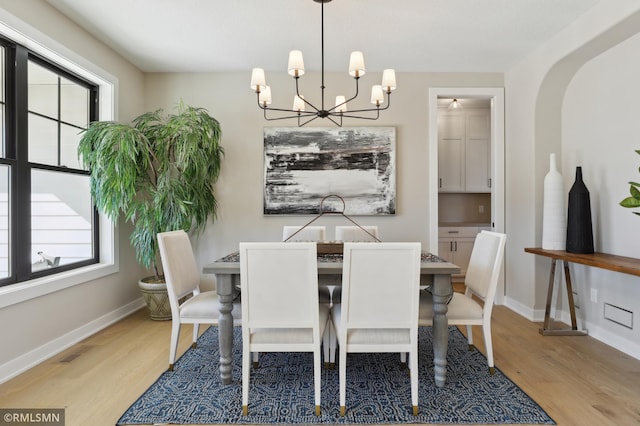 dining area featuring light hardwood / wood-style floors, an inviting chandelier, and a healthy amount of sunlight