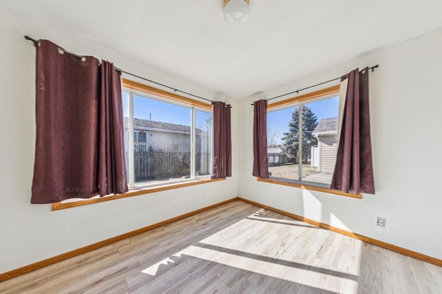 983 County Road D E, Vadnais Heights, MN 55109 - spare room with a wealth of natural light, baseboards, and wood finished floors