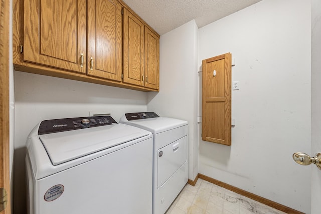 983 County Road D E, Vadnais Heights, MN 55109 - laundry area with light floors, a textured ceiling, washing machine and dryer, baseboards, and cabinet space