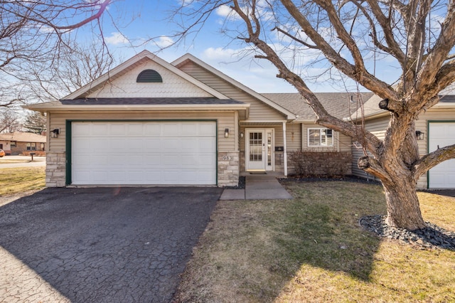 983 County Road D E, Vadnais Heights, MN 55109 - view of front of property featuring roof with shingles, driveway, stone siding, an attached garage, and a front lawn