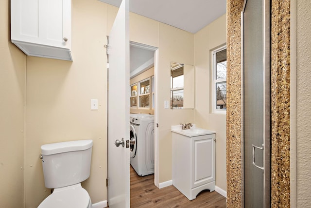 bathroom featuring washer / clothes dryer, vanity, wood-type flooring, and toilet