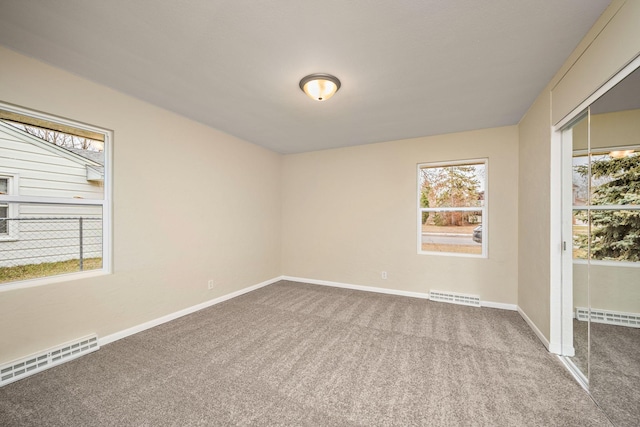 unfurnished room with carpet floors and baseboard heating