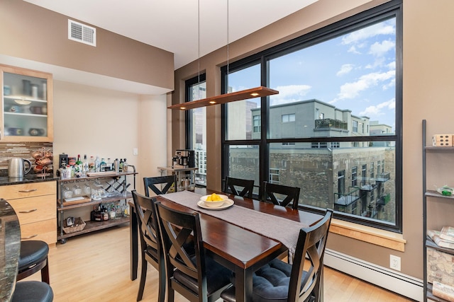 dining area featuring light hardwood / wood-style floors and baseboard heating