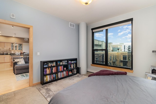 bedroom featuring a baseboard radiator and light hardwood / wood-style flooring