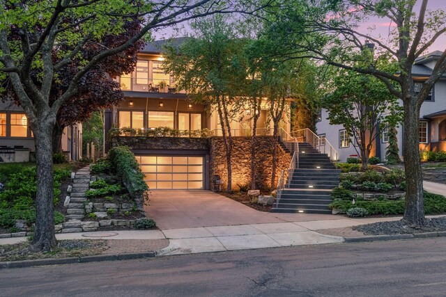 4540 Upton Ave S, Minneapolis, MN 55410 - view of front facade with stairway, a garage, concrete driveway, and stucco siding