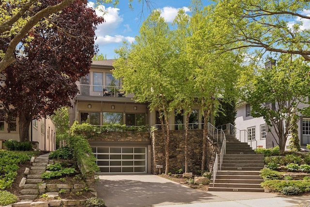 4540 Upton Ave S, Minneapolis, MN 55410 - view of property hidden behind natural elements with stairs, stucco siding, a garage, and concrete driveway