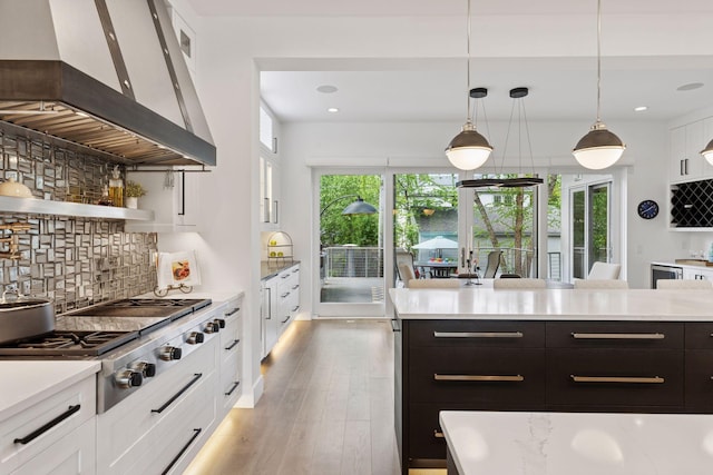 4540 Upton Ave S, Minneapolis, MN 55410 - kitchen with wall chimney range hood, white cabinetry, light countertops, tasteful backsplash, and recessed lighting
