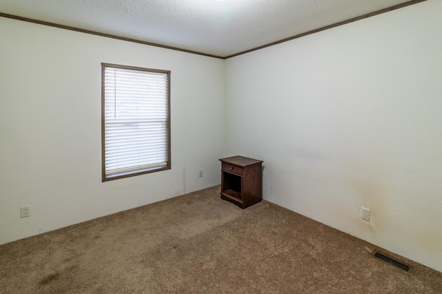 unfurnished room with carpet floors, a textured ceiling, and ornamental molding