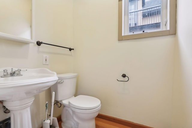 bathroom with hardwood / wood-style floors and toilet