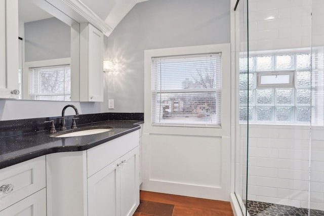 bathroom with hardwood / wood-style flooring, vanity, lofted ceiling, and a shower with door