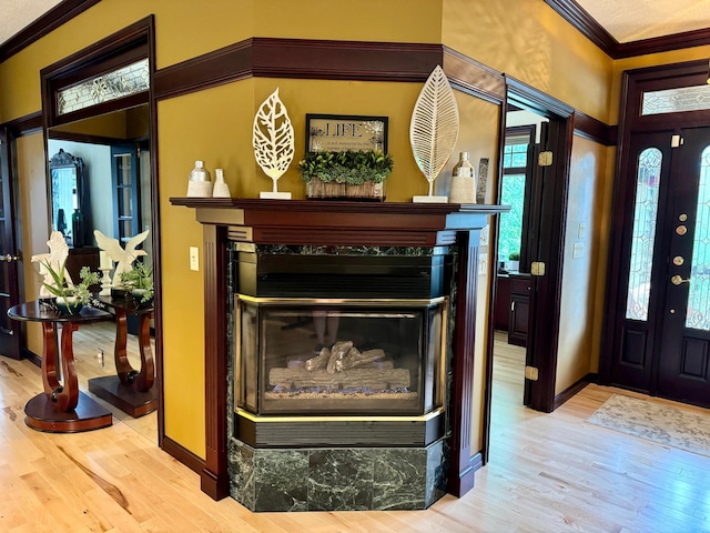 interior space with a multi sided fireplace, wood-type flooring, and crown molding