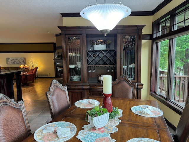 dining space with hardwood / wood-style floors, a textured ceiling, and crown molding