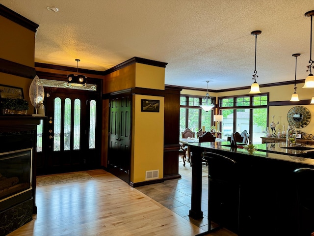 foyer with hardwood / wood-style flooring, crown molding, and sink