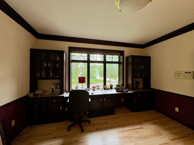 home office with light hardwood / wood-style floors, a textured ceiling, and ornamental molding