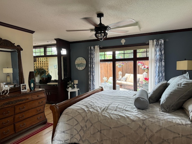 bedroom with a textured ceiling, light wood-type flooring, ceiling fan, and crown molding