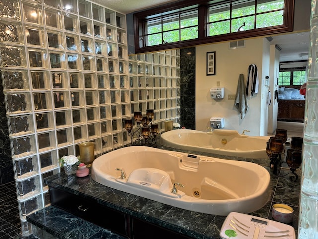 bathroom with tiled bath and a wealth of natural light