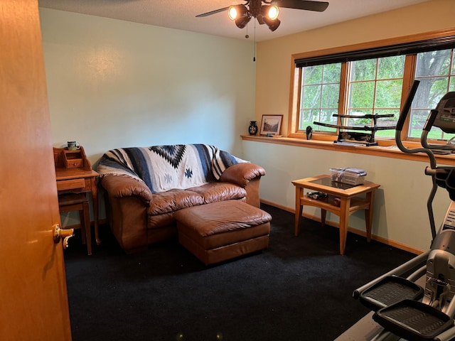 living room featuring dark carpet and ceiling fan