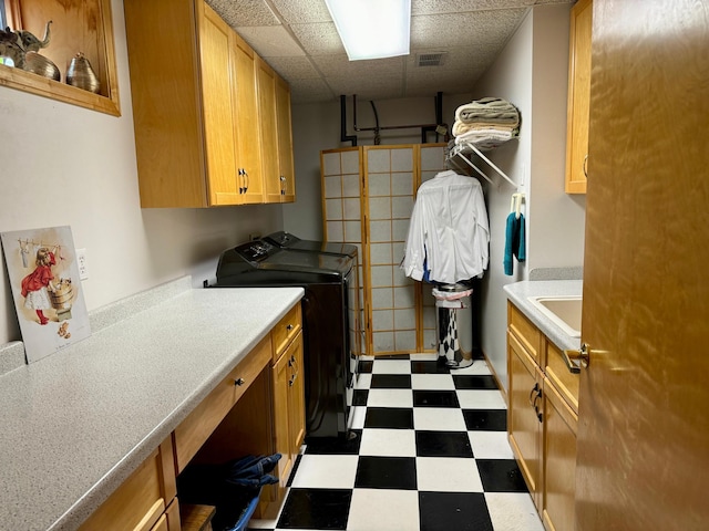 laundry room with cabinets, independent washer and dryer, and sink