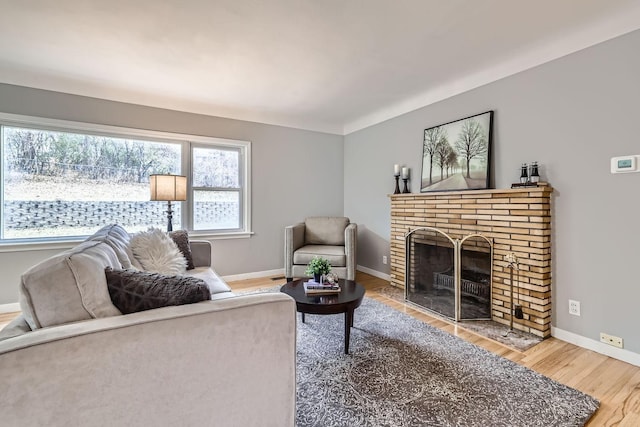 living room featuring a brick fireplace and hardwood / wood-style flooring