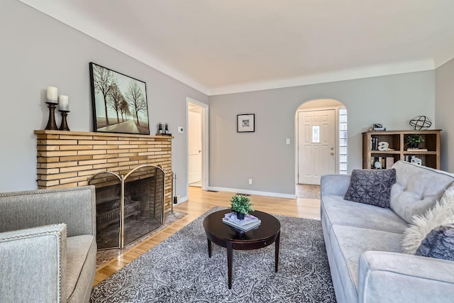 living room with hardwood / wood-style flooring and a brick fireplace