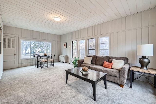 carpeted living room with a wealth of natural light, wood walls, and wood ceiling