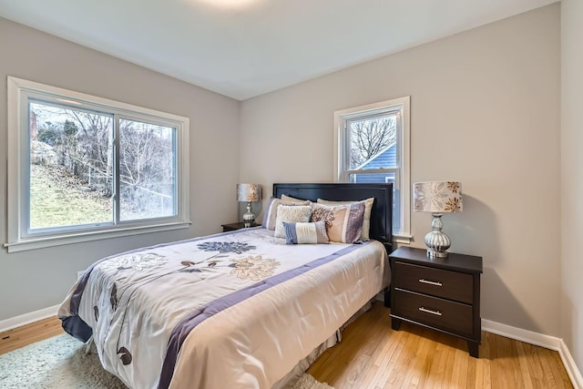 bedroom with light hardwood / wood-style floors and multiple windows