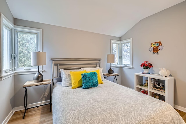 bedroom with wood-type flooring and vaulted ceiling