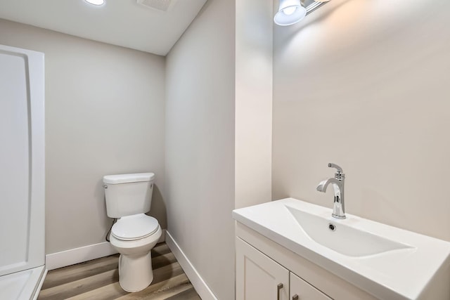 bathroom with hardwood / wood-style floors, vanity, and toilet