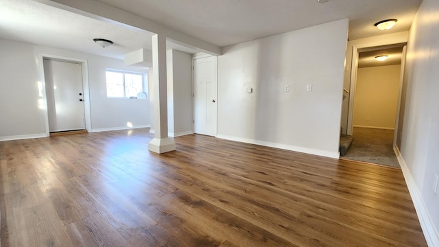 empty room featuring dark wood-type flooring and a textured ceiling